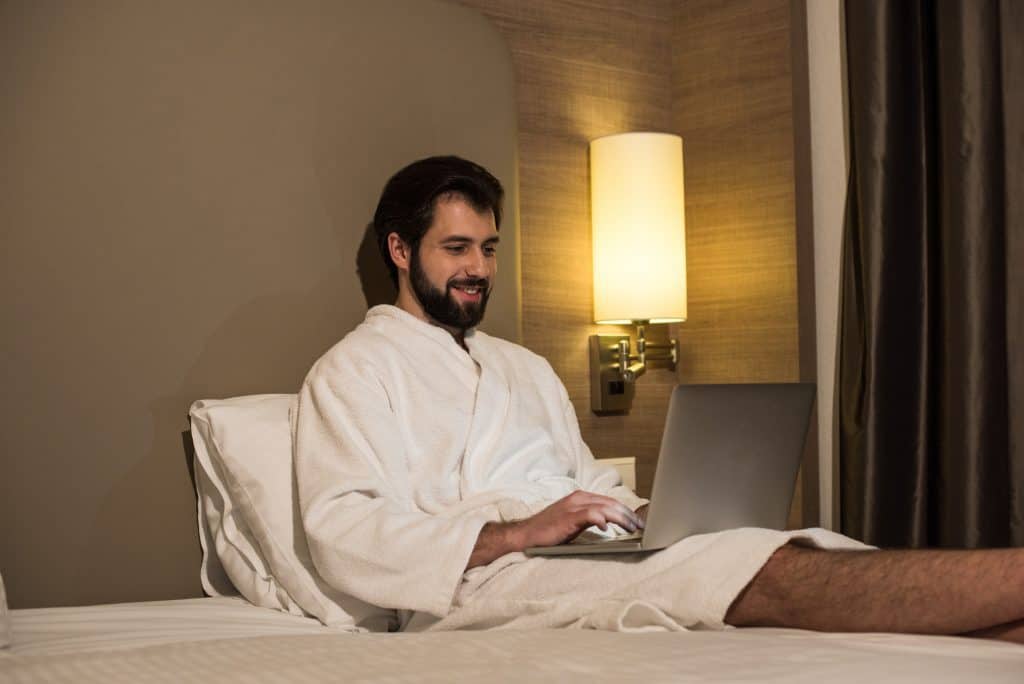 Man In Bed Using His Laptop