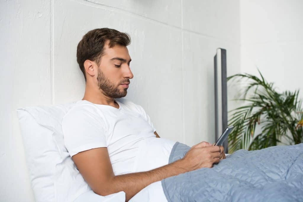 Man On His Bed With A Laptop